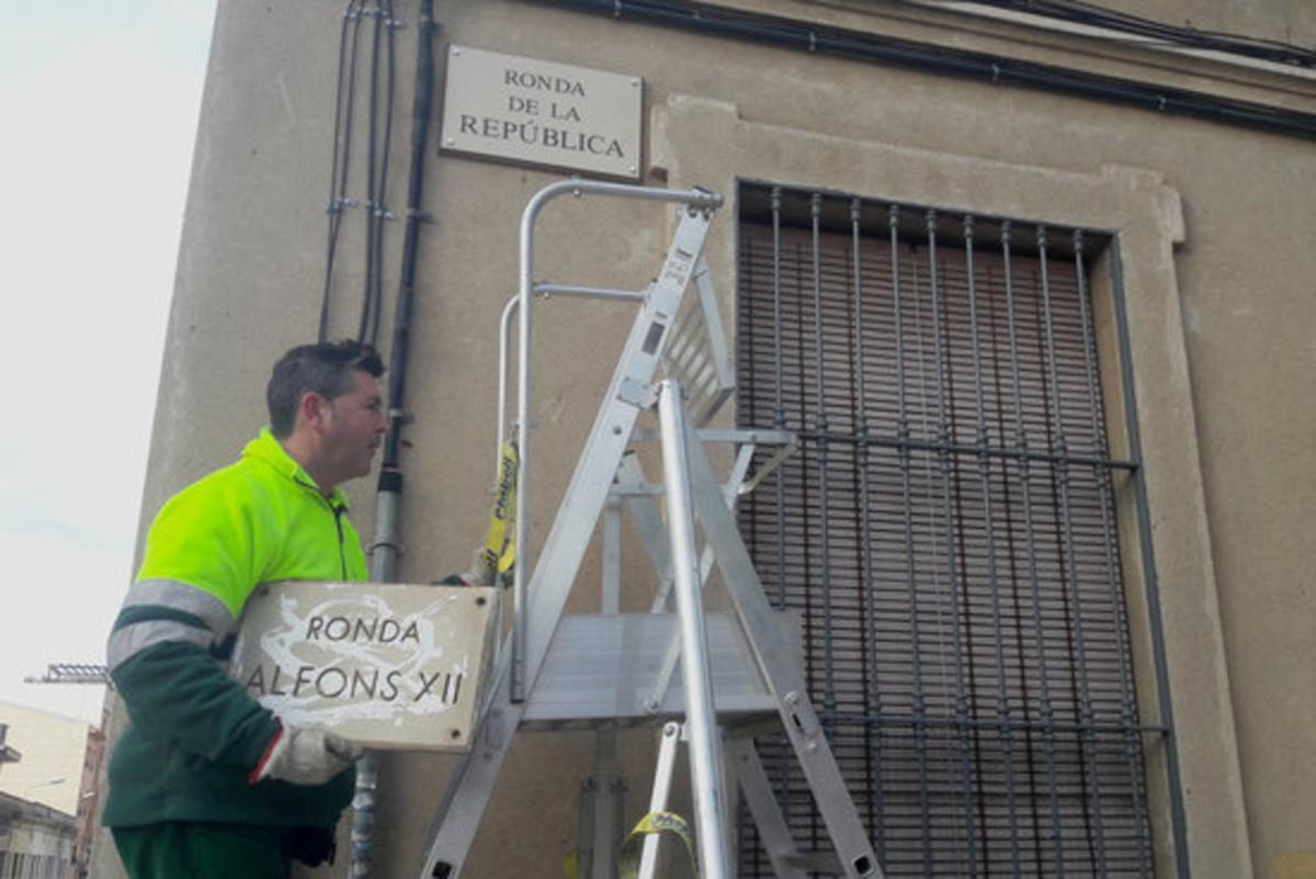 Un operari retira el cartell de la Ronda Alfons XII de Mataró.