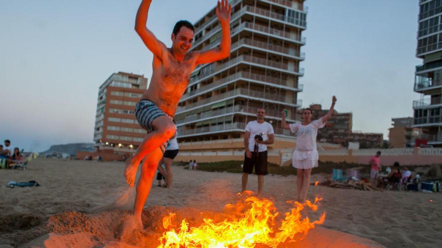 Un joven salta la hoguera en una de las playas de Elche el pasado año