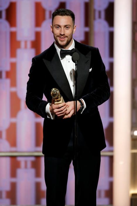 Actor Aaron Taylor-Johnson holds up his trophy ...