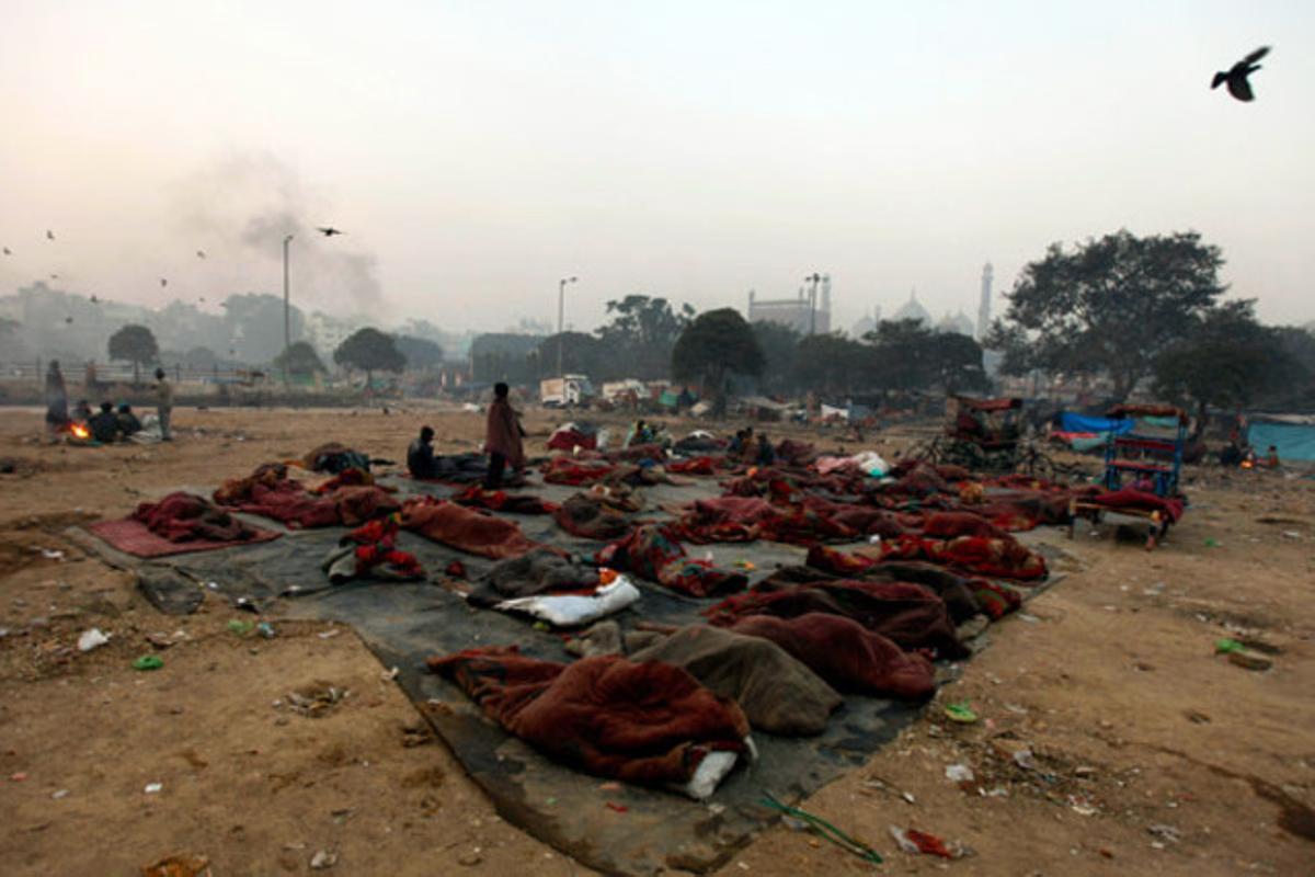Un grup de persones sense sostre descansa en un descampat prop de la mesquita Jama a Nova Delhi (Índia).