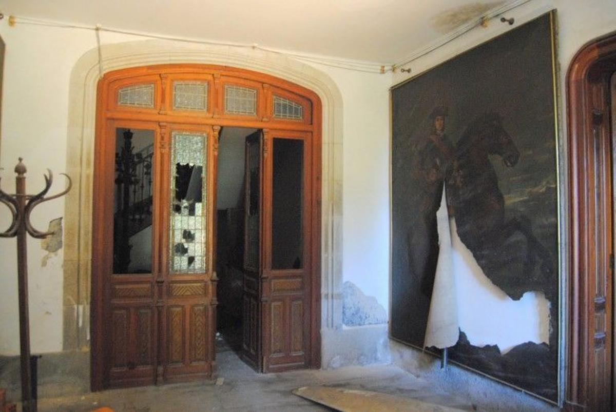 El acceso a la escalera central de la casona, con un cuadro destrozado a su derecha