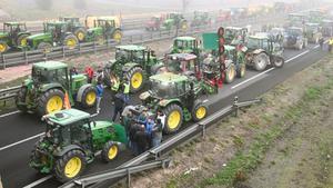Agricultores con tractores cortan el paso en la autovía NII a su paso por Fondarella, en el Pla dUrgell (Lleida).