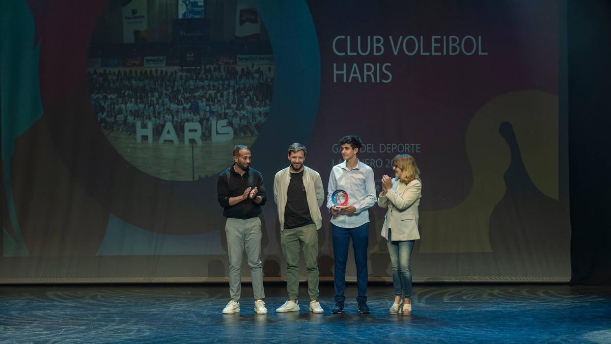 Latorre (chaqueta beige) recoge el premio, junto a David Martín (izquierda) y uno de los jugadores del cadete del CV Haris
