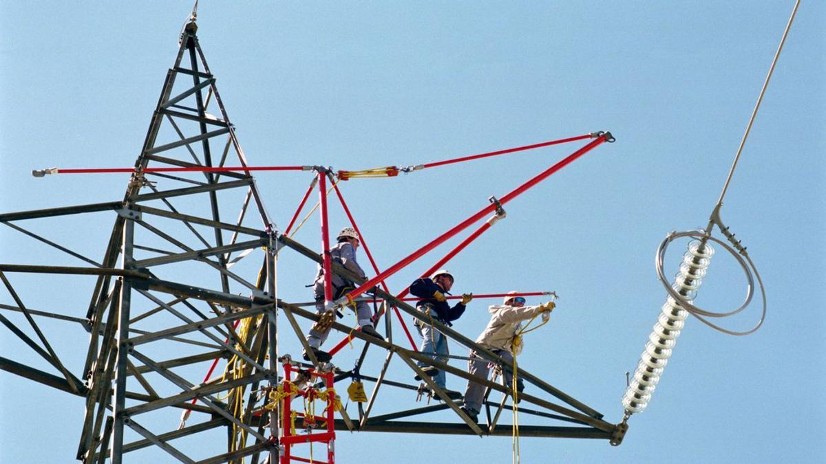 Tres operararios trabajando en una red de alta tensión.