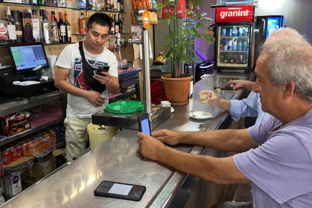 Un cliente de un bar de Mollet del Vallès recibe el aviso de simulacro de emergencia en su móvil, a las 10 de la mañana.