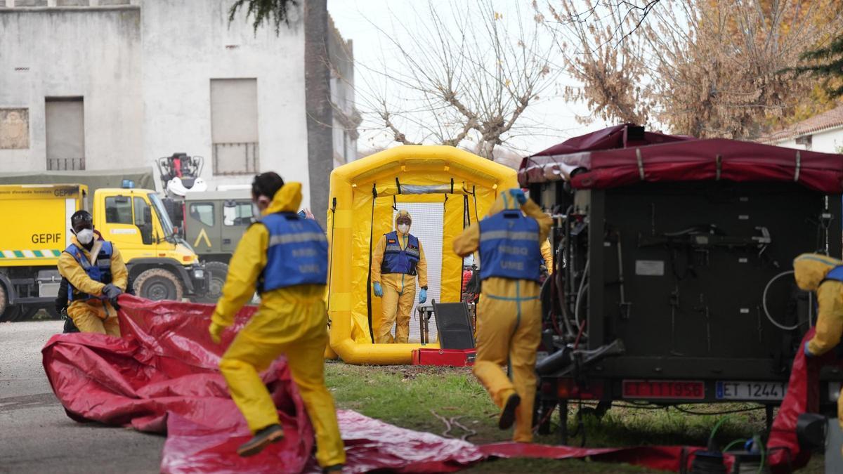 Miemebros de la UME desinfectan vehículos en una zona próxima a Barcelona.