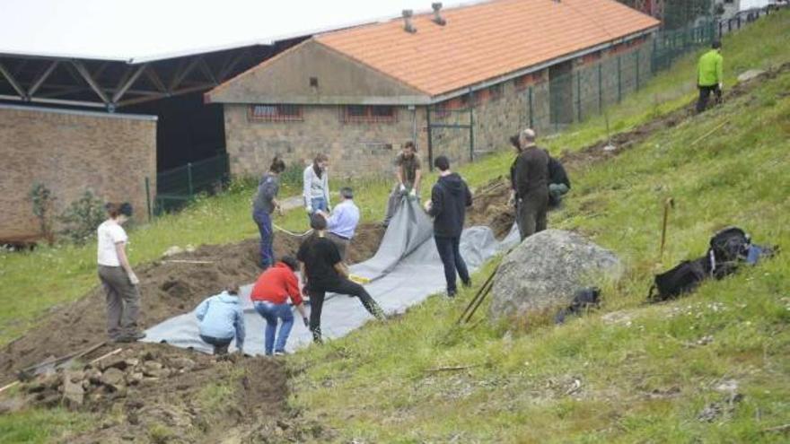 Voluntarios de la UDC y Adega construyendo el humedal, ayer en el Monte da Fraga. / 13fotos