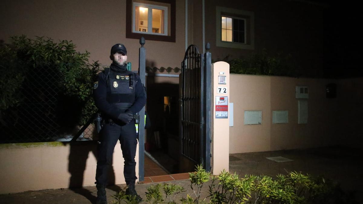 Un policía nacional custodia el domicilio en el que se han localizado los cadáveres de un hombre y una mujer muertos por disparos, a 31 de enero de 2023 en La Línea (Cádiz, Andalucía, España).