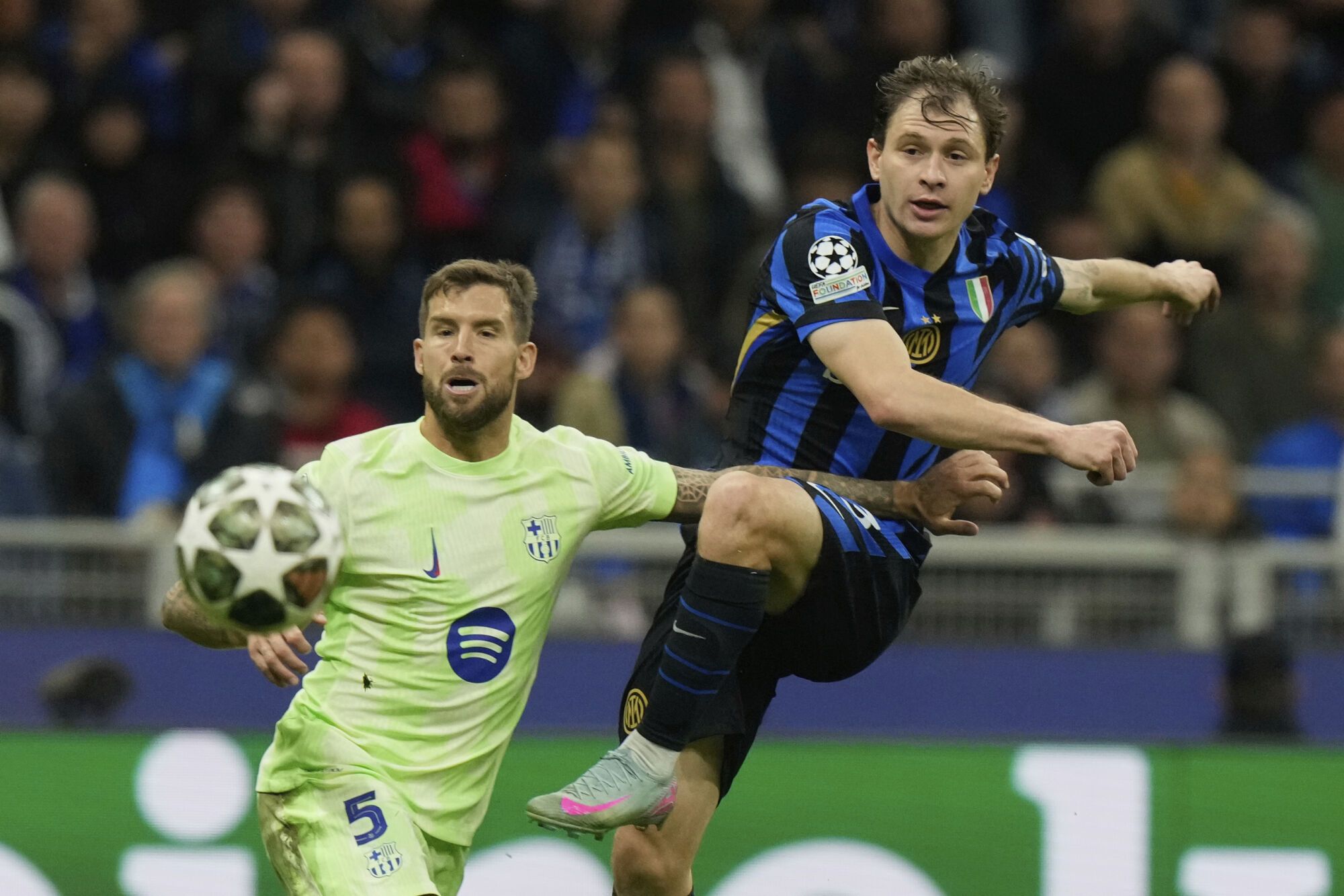Inter Milan's Nicolo Barella, right, attempts a shot at goal in front of Barcelona's Inigo Martinez during the Champions League semifinal second leg soccer match between Inter Milan and Barcelona at San Siro stadium in Milan , Italy, Tuesday, May 6, 2025. (AP Photo/Luca Bruno). EDITORIAL USE ONLY / ONLY ITALY AND SPAIN