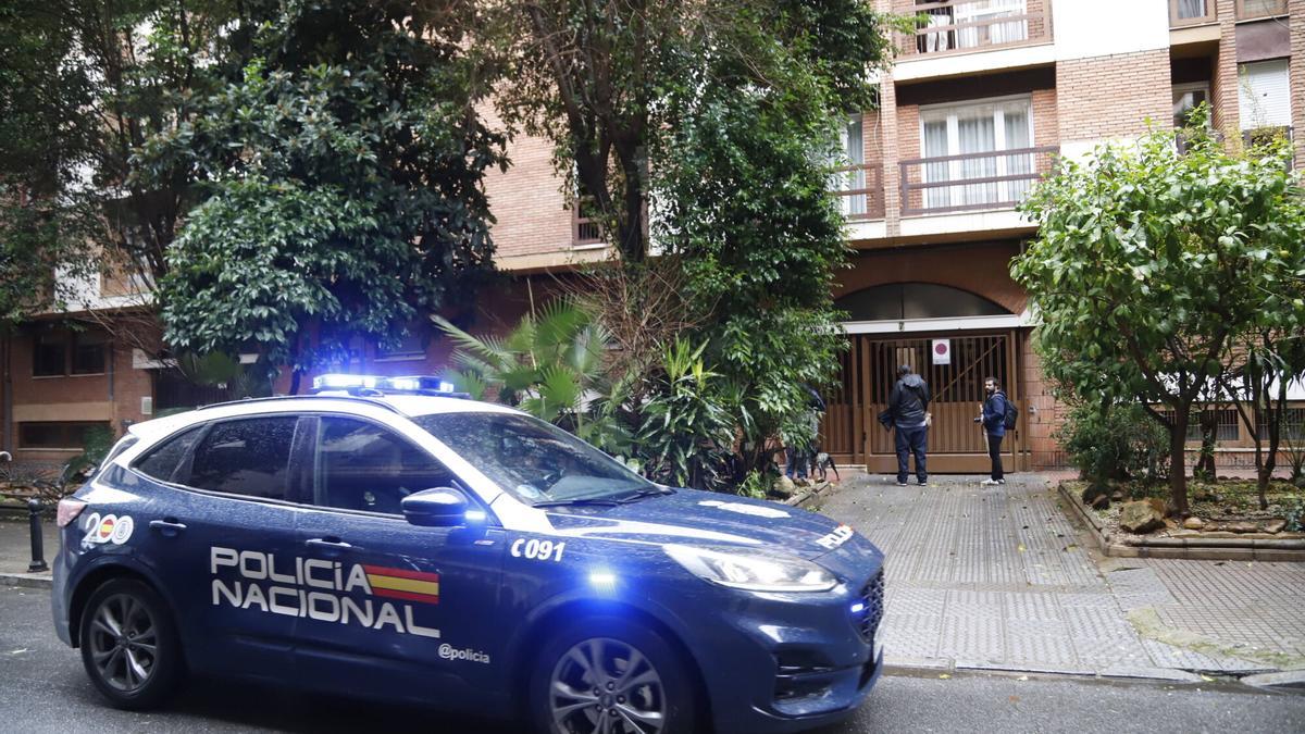 Un coche de la Policía Nacional junto al portal de la vivienda de Ciudad Jardín donde encontraron a una joven de 30 años fallecida, este martes.