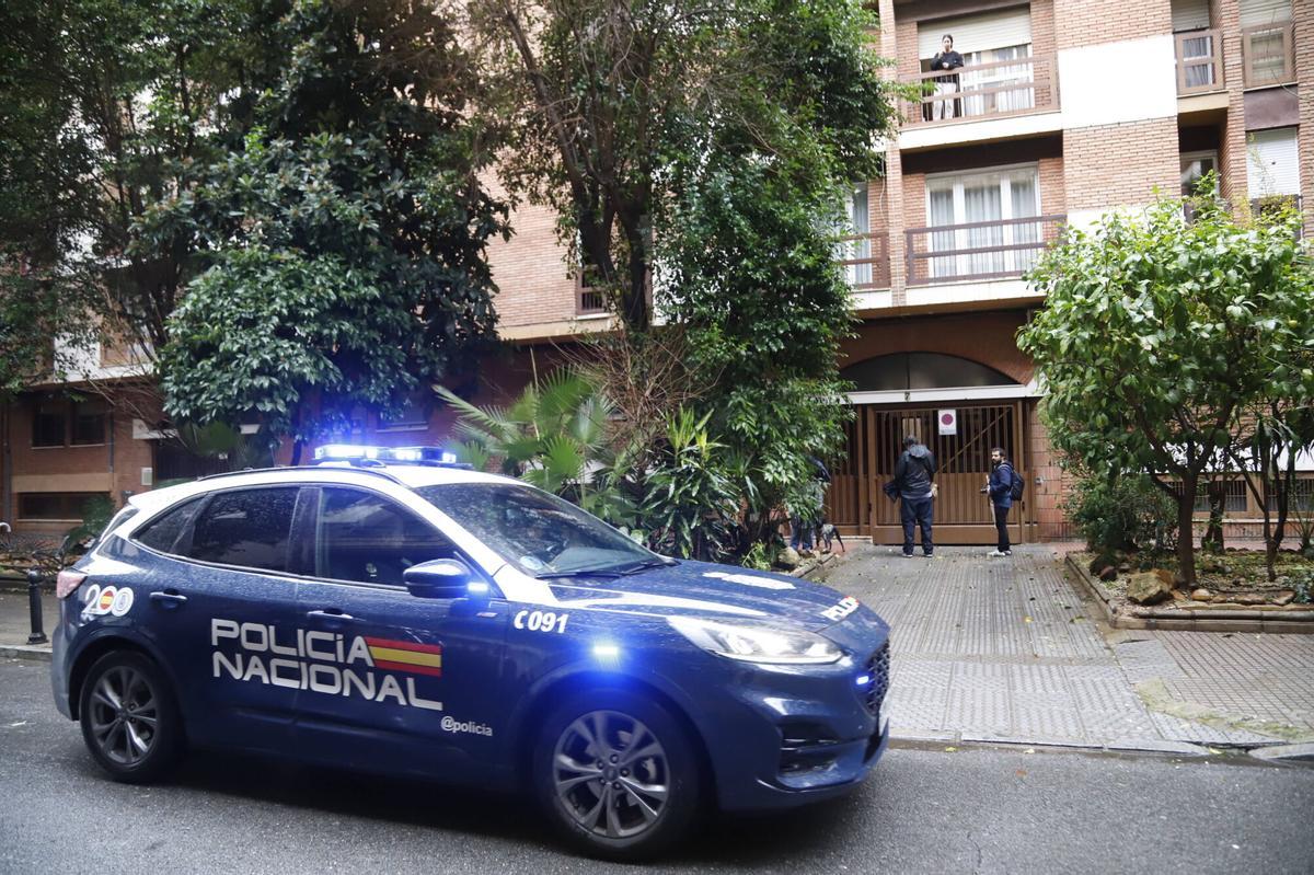 Un coche de la Policía Nacional junto al portal de la vivienda de Ciudad Jardín donde encontraron a una joven de 30 años fallecida, este martes.