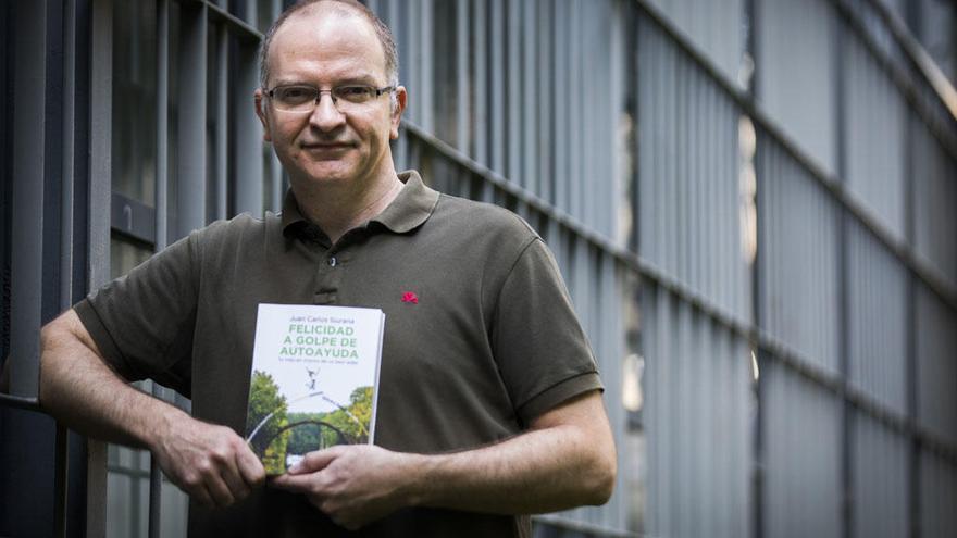 Juan Carlos Siurana, autor de «Felicidad a golpe de autoayuda», con su libro en la Universitat de València.