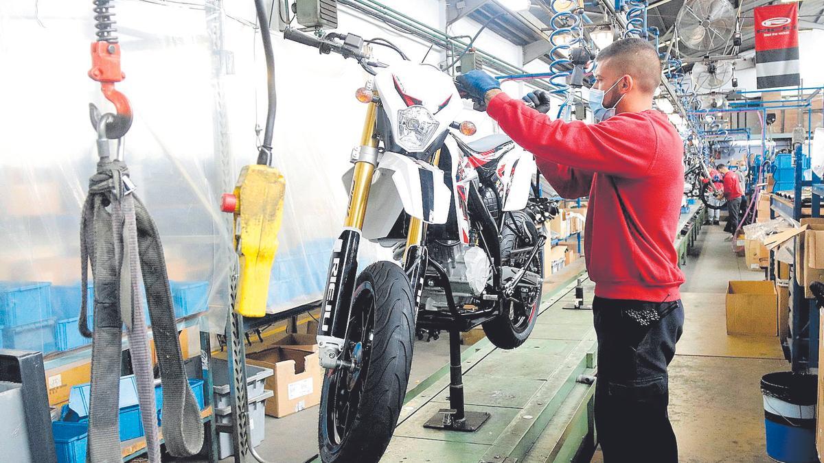 Un treballador de Rieju acabant de muntar una moto elèctrica en una de les dues cadenes de muntatge de la fàbrica de Figueres.