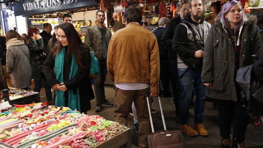 Turistes amb maleta visitant el mercat de la Boqueria