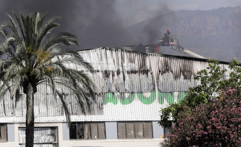 Los bomberos refrescan con agua la zona afectada para evitar que el fuego rebrote.