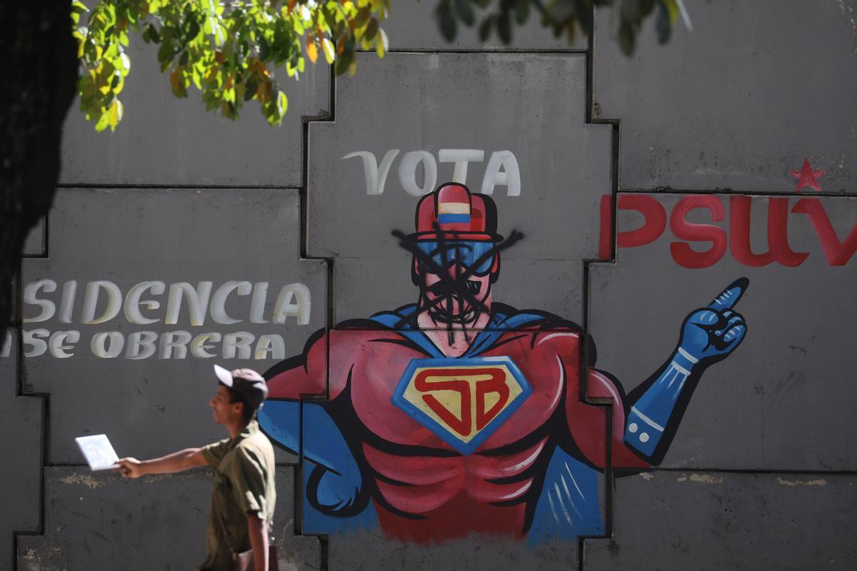 Una persona camina junto a un mural con la imagen del presidente de Venezuela, Nicolas Maduro, representado como 'Super Bigote' en los alrededores de El Helicoide, en Caracas (Venezuela).