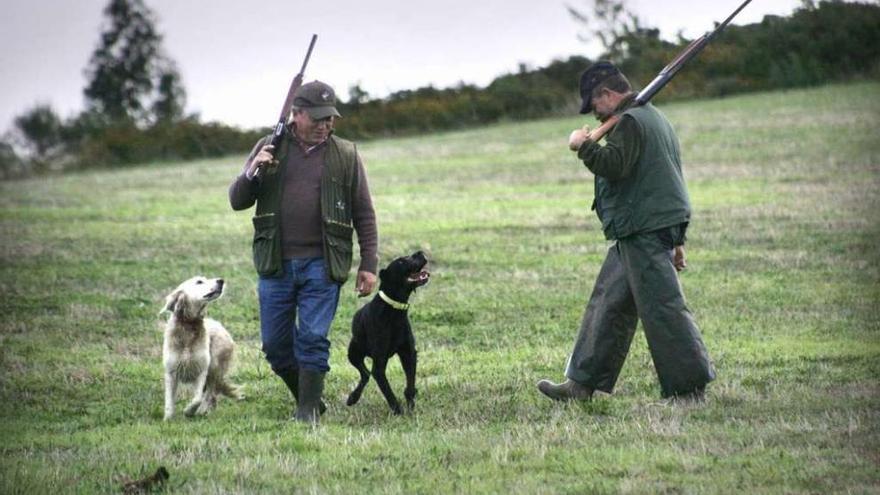 Dos cazadores con sus perros, ayer, en un monte gallego en el inicio de la temporada de caza.