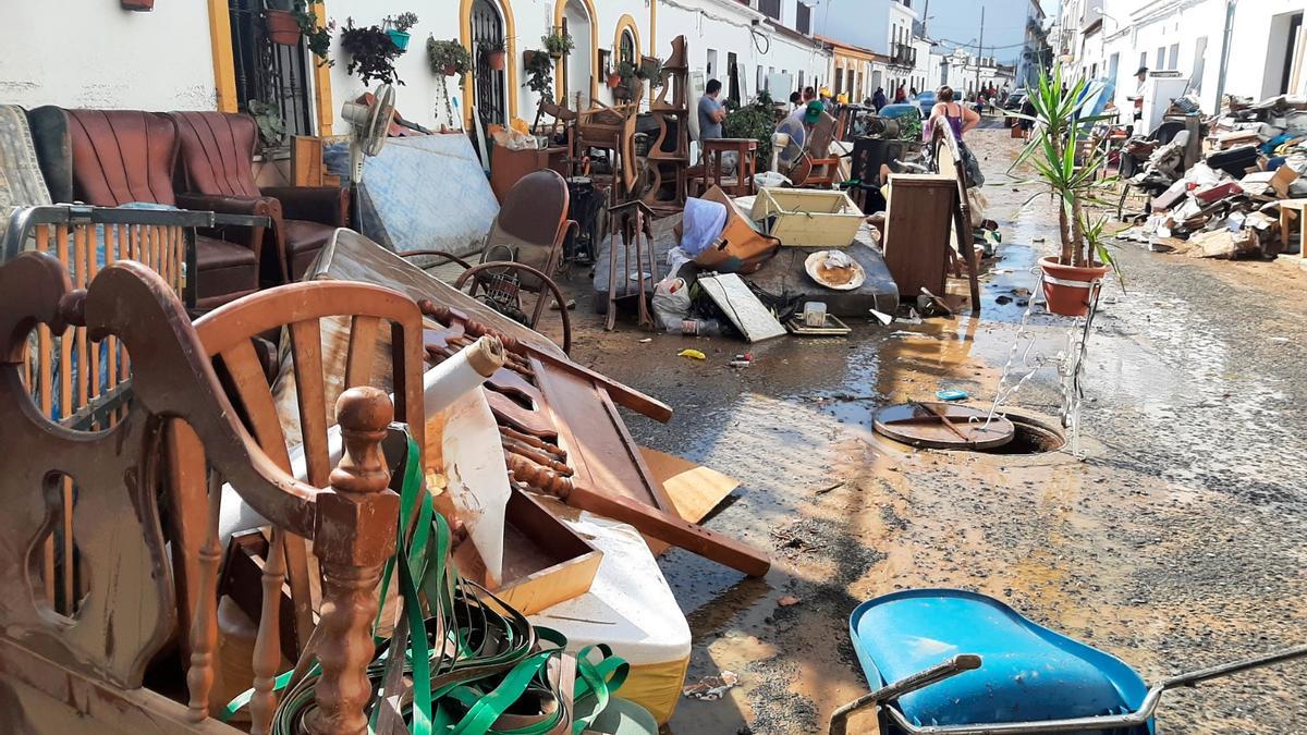 Una calle de Lepe llena de muebles afectados por el agua.