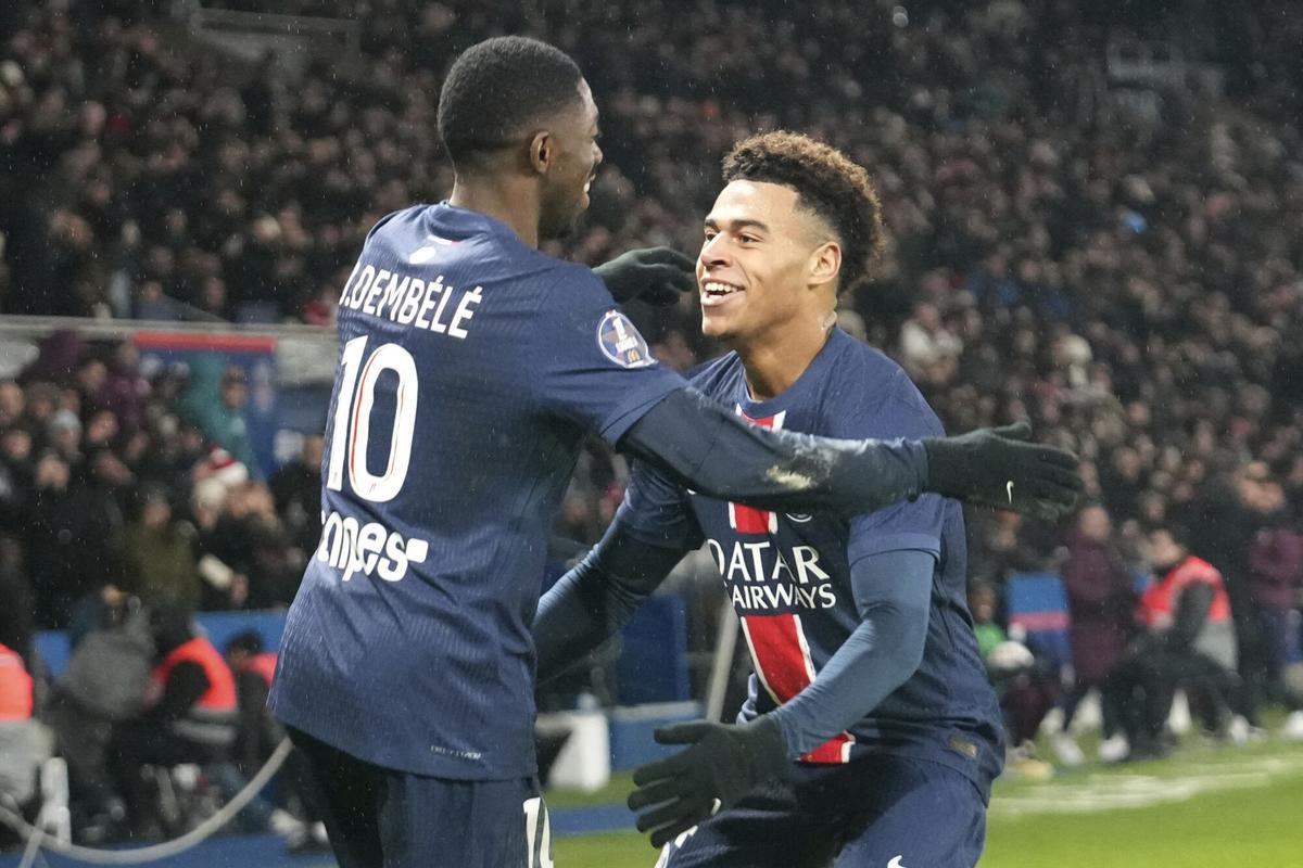PSG's Ousmane Dembele, left, celebrates with PSG's Desire Doue after scoring his sides third goal during the French League One soccer match between Paris Saint-Germain and Monaco at Parc des Princes stadium in Paris, Friday, Feb. 7, 2025. (AP Photo/Michel Euler)