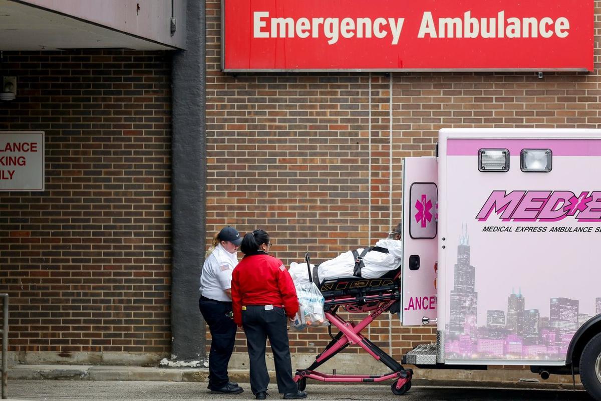 Emergency medical service workers place a patient into an ambulance outside the University of Illinois Hospital as the Illinois Nurses Association reports 12 registered nurses tested positive for the coronavirus disease (COVID-19), in Chicago, Illinois, U.S. March 27, 2020. REUTERS/Joshua Lott