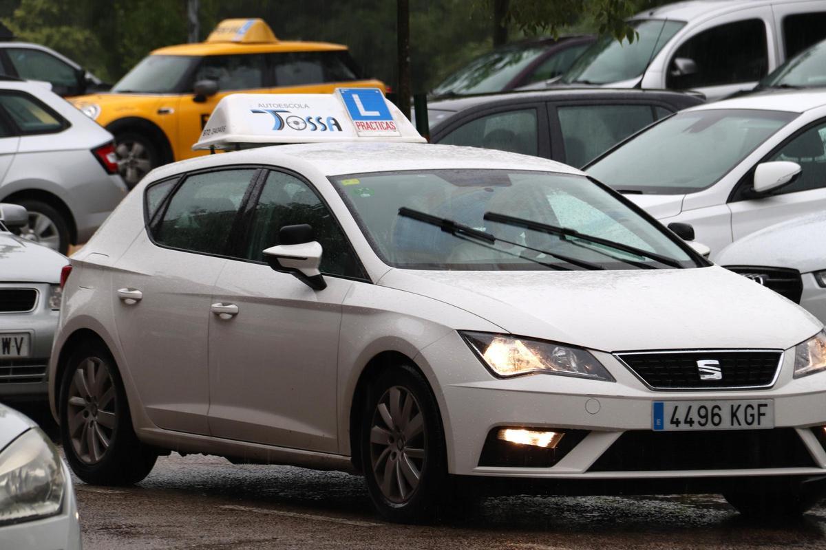 Un cotxe de l'autoescola de Tossa conduint sota la pluja, en una imatge d'arxiu.