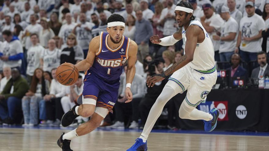 Jaden McDaniels, a la derecha, defiende a Devin Booker en el Wolves-Suns del martes. |