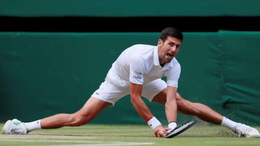 Novak Djokovic se estira durante la final para devolver de revés ante Federer.