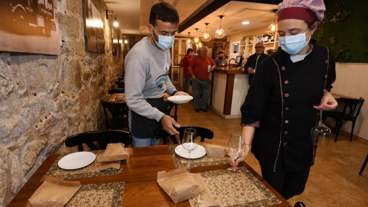 Profesionales del PonteTapas, ayer, preparando una mesa de su local.