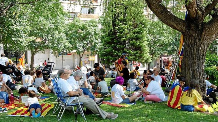 Visitants descansant després de dinar als jardins de la zona del passeig de la Pau