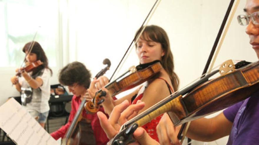 Lam Tim Wai, Polina Zakharyan y al fondo, Núria Prieto, tocan un violín barroco.