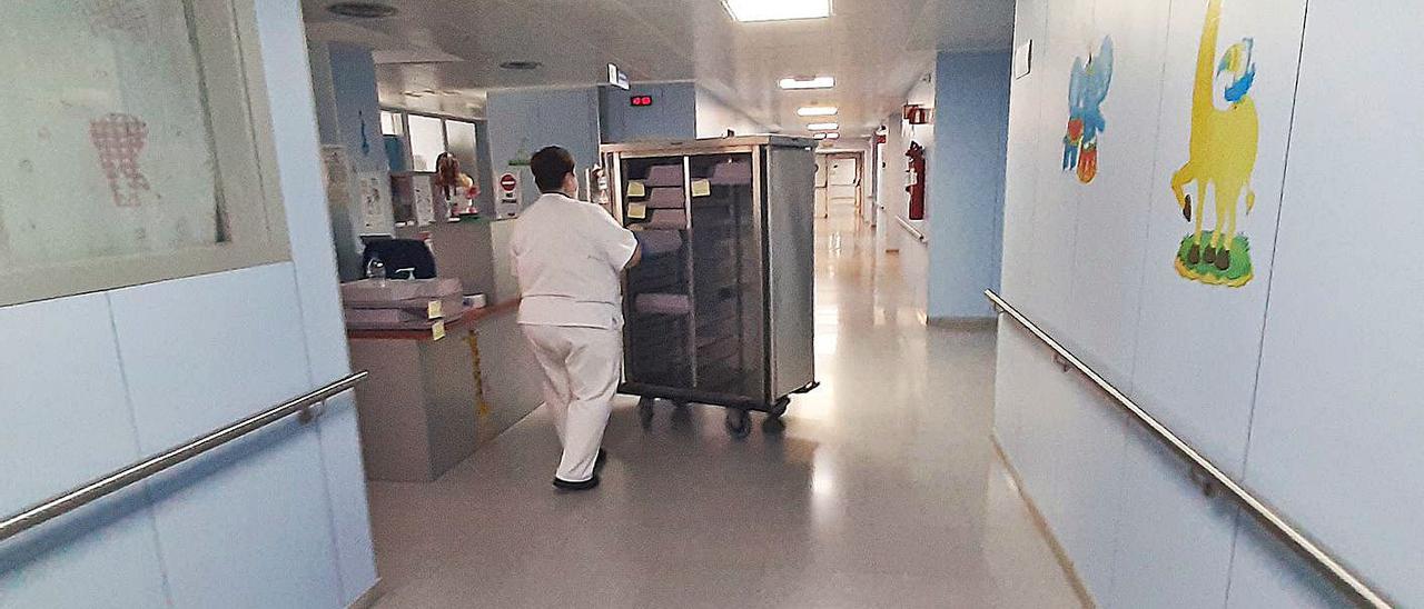 Una auxiliar de enfermería transporta un carro de comida por  la Unidad de Maternidad del hospital majorero. | | LP/DLP