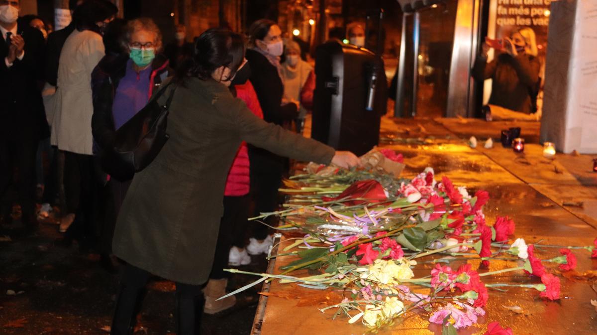 Diverses dones fent una ofrena de flors per totes les víctimes per violència masclista el 25 de novembre de 2021