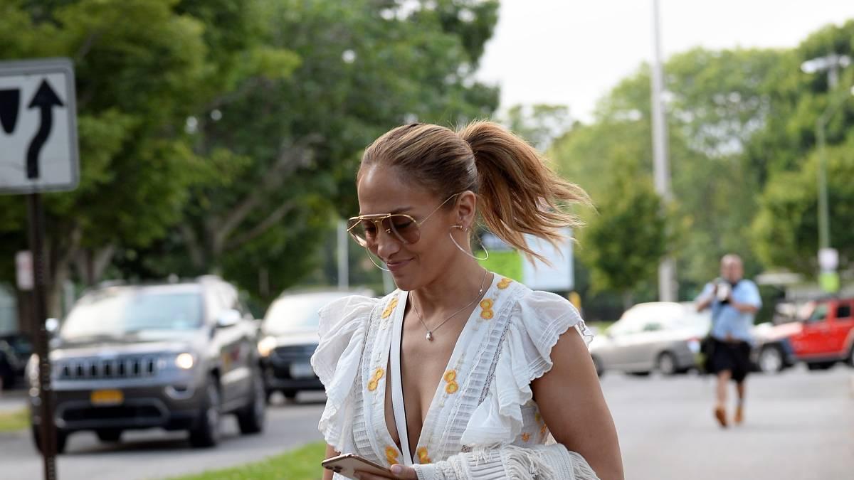 Jennifer Lopez con vestido blanco con bordados amarillos y sandalias planas