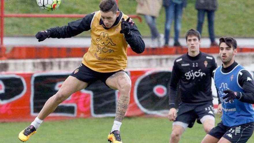 Sanabria remata un balón de cabeza en el entrenamiento de ayer ante la mirada de Pablo Pérez y Julio.