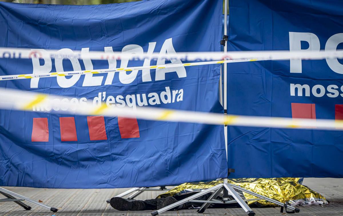 El cos del mort a la Barceloneta, tapat amb una manta tèrmica, rere una lona dels Mossos. | MANU MITRU