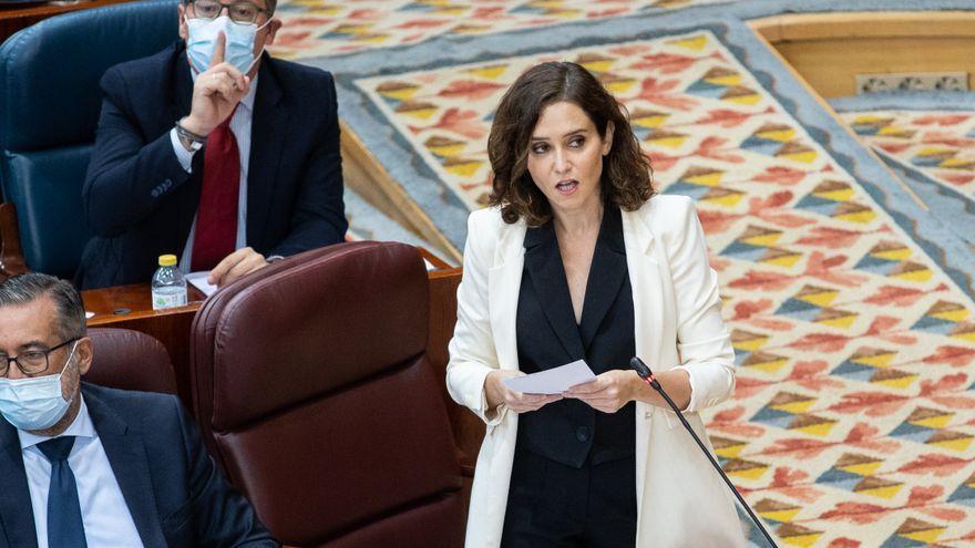 Díaz Ayuso, y Alfonso Serrano (al fondo), en un Pleno de la Asamblea.