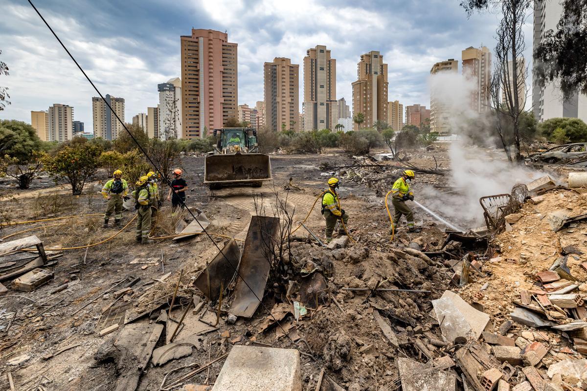 Bomberos y bomberos forestales, refrescando la zona este jueves con la ayuda de mangueras y una pala excavadora.