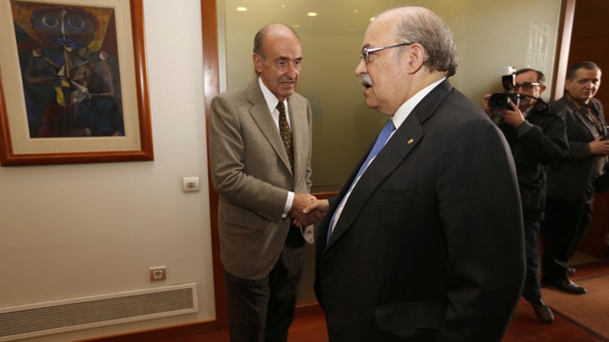 Andreu Mas-Colell (derecha) saluda a Miquel Roca, el miércoles en Barcelona.