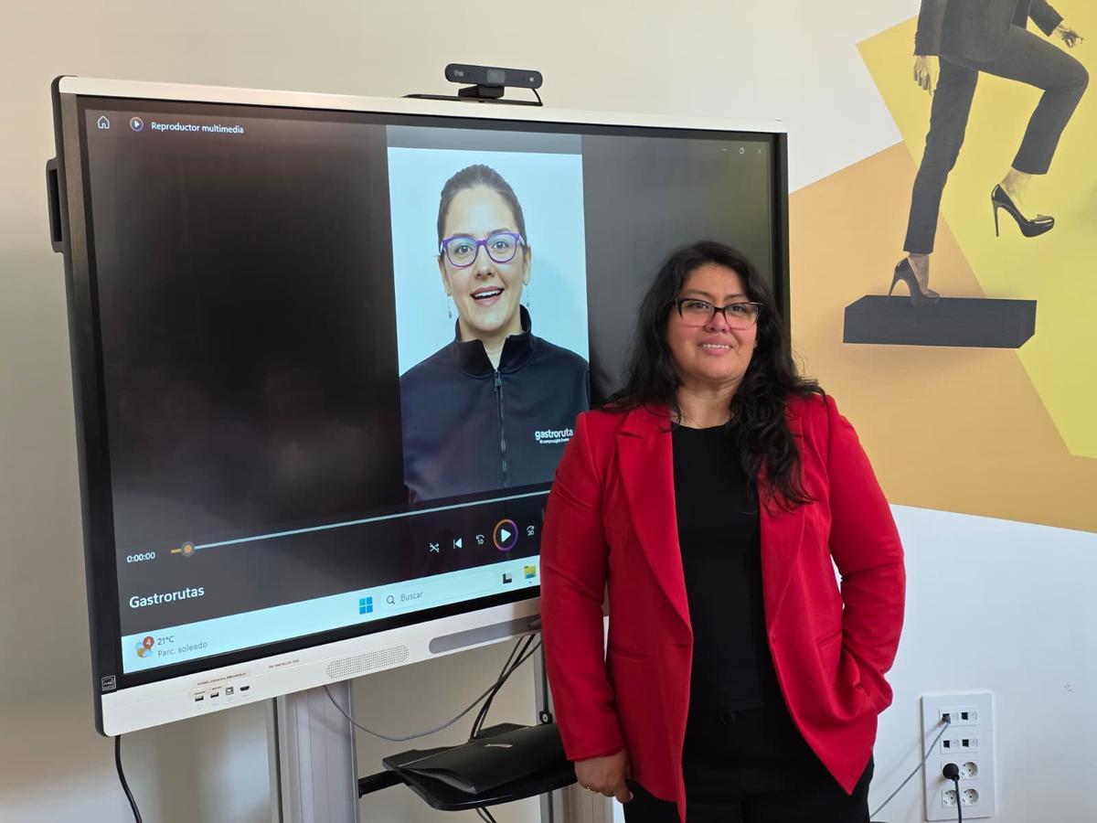 Selia Rojas, ganadora del concurso, posando junto al vídeo presentación de su proyecto, Gastrorutas.