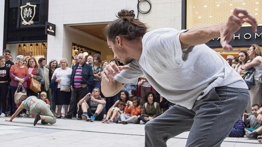 Selene Martínez, al fondo a la izquierda, y Miguel Pérez, durante la representación de danza, ayer, en la calle Pelayo.