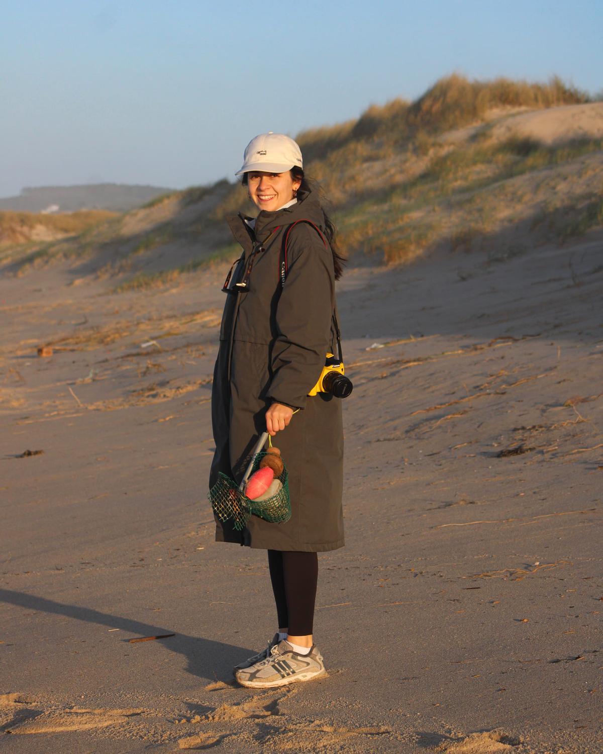 Laura Boor facendo recollida de boias nunha praia galega.