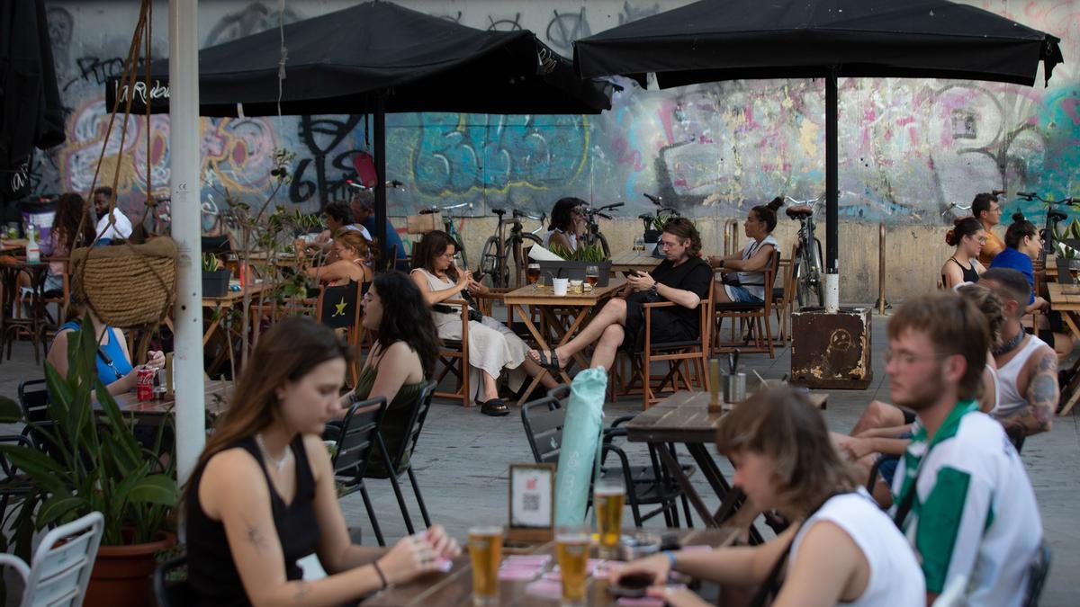 Varias personas sentadas en la terraza de un bar en Barcelona.
