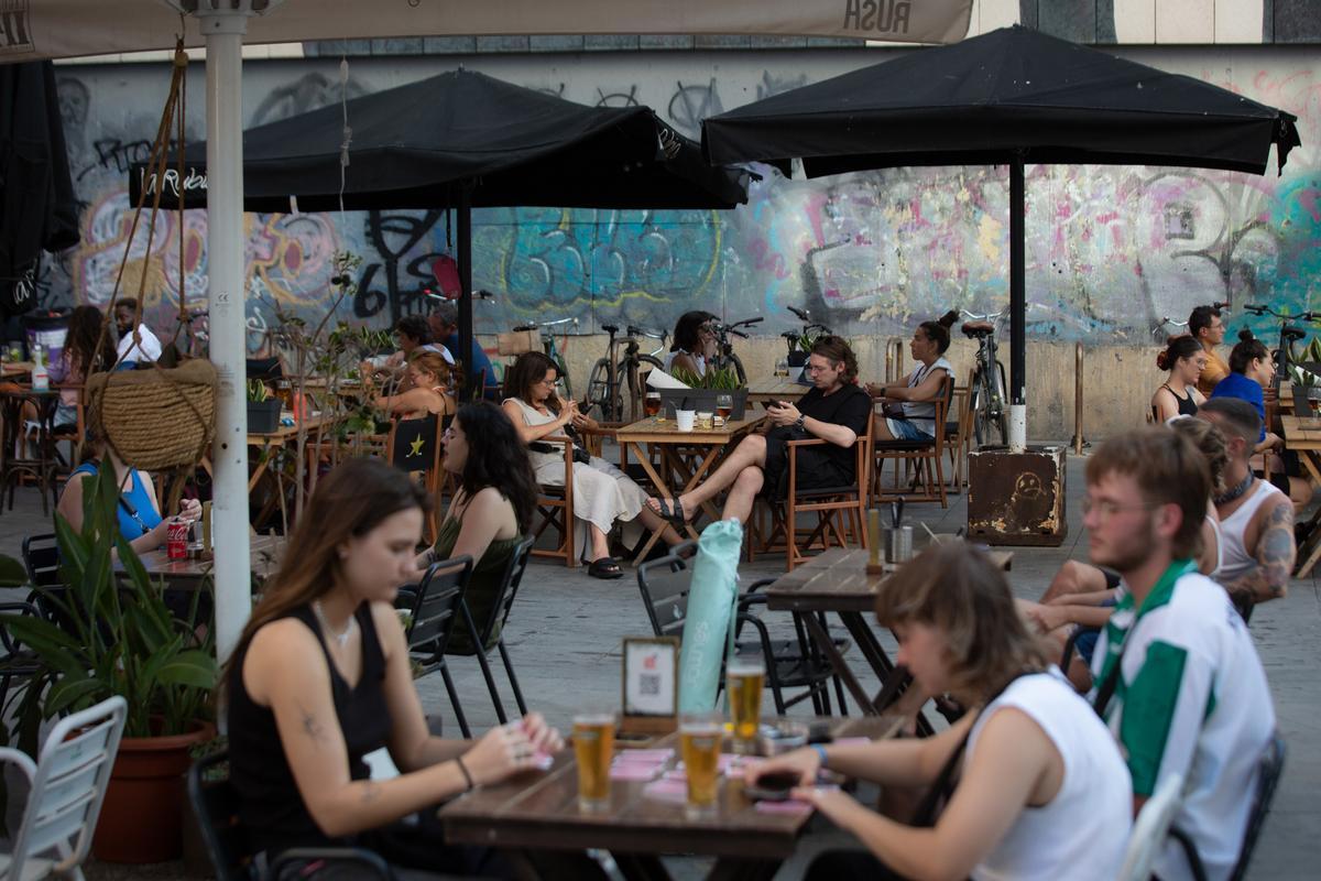 Archivo - Varias personas sentadas en la terraza de un bar en Barcelona