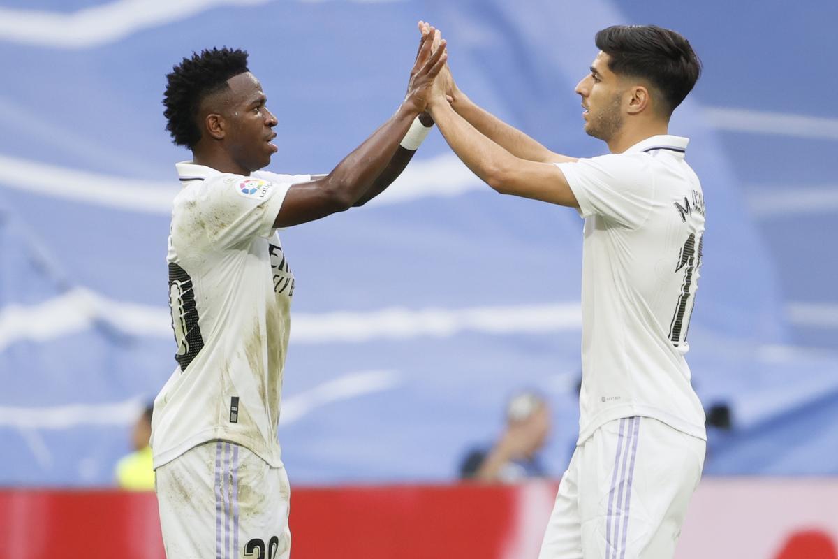 MADRID, 04/06/2023.- El centrocampista del Real Madrid, Marco Asensio (d) se saluda con su compañero, el brasileño Vinicius Jr., antes de abandonar el terreno de juego durante el encuentro que Real Madrid y el Athletic Club de Bilbao disputan este domingo en el estadio Santiago Bernabéu. EFE/ Mariscal.