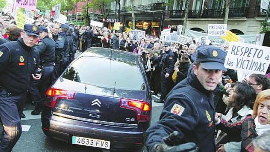 La Policía se despliega en torno al coche de Garzón mientras cientos de manifestantes lanzan gritos en su favor.