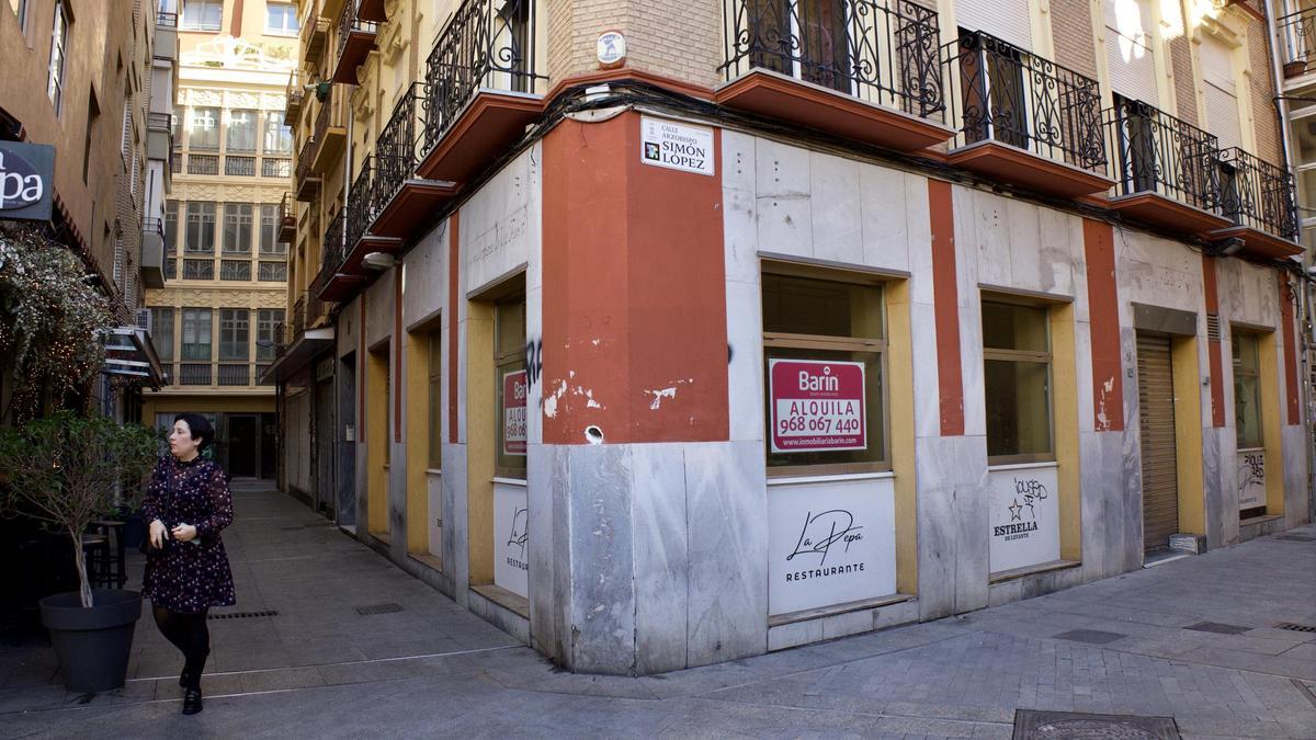Local cerrado en el entorno de la Plaza de las Flores de Murcia, con un cartel de 'se alquila'.