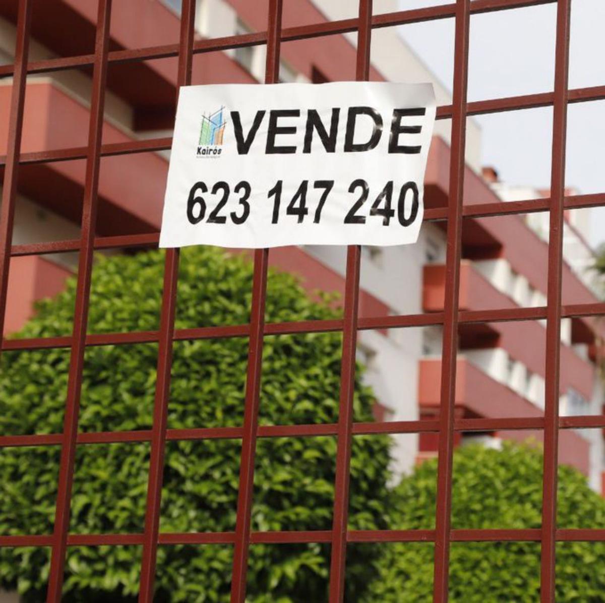 Cartel de «se vende» en la cancela de entrada de unos pisos en Córdoba capital. | A. J. GONZÁLEZ