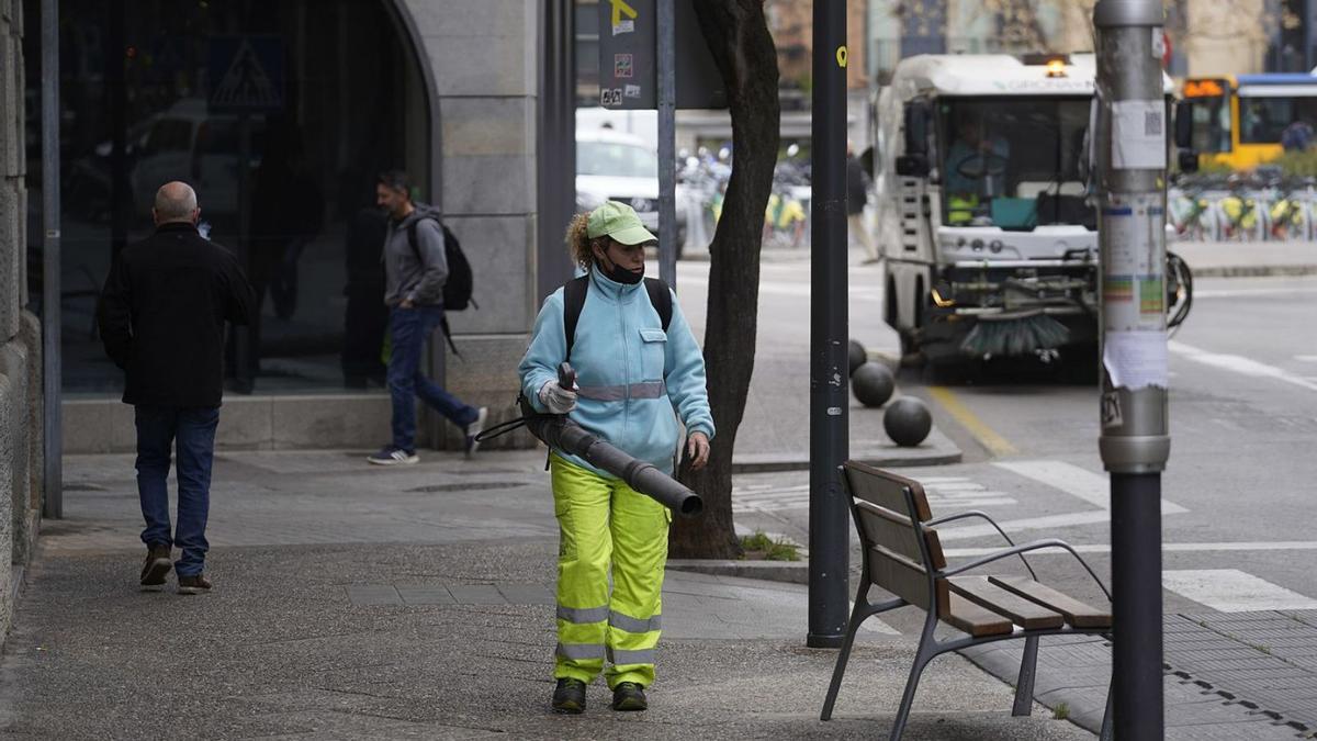 Una treballadora netejant un carrer de Girona, en una imatge d’arxiu.  | MARC MARTÍ