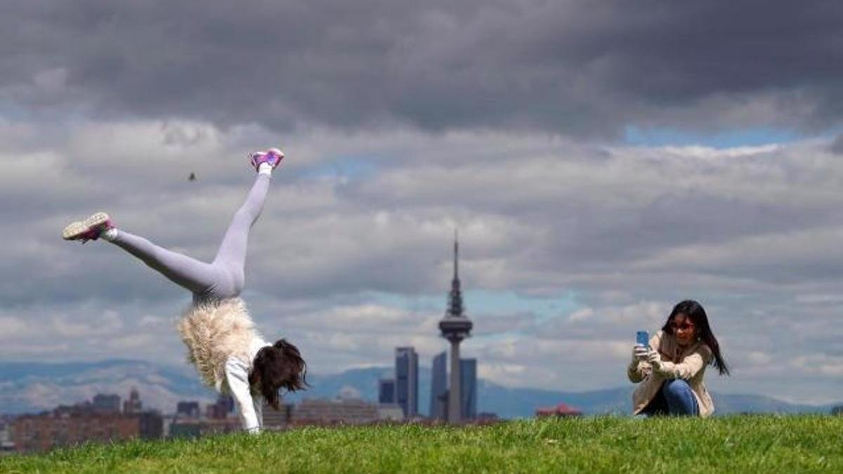 Una niña juega en un parque de Madrid mientas su madre le hace una foto.