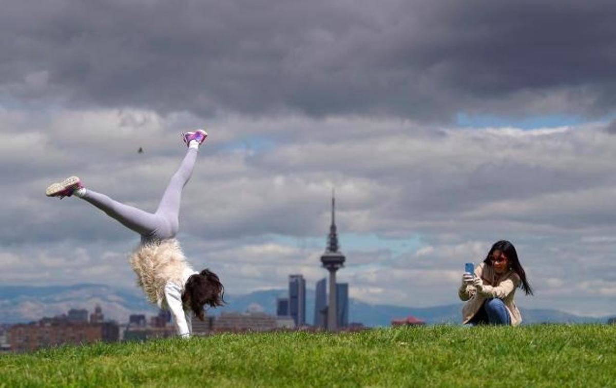 Una niña juega en un parque de Madrid mientas su madre le hace una foto.